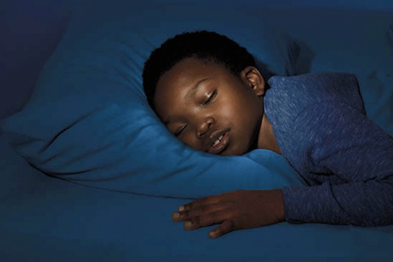 A Young Boy sleeping on his bed